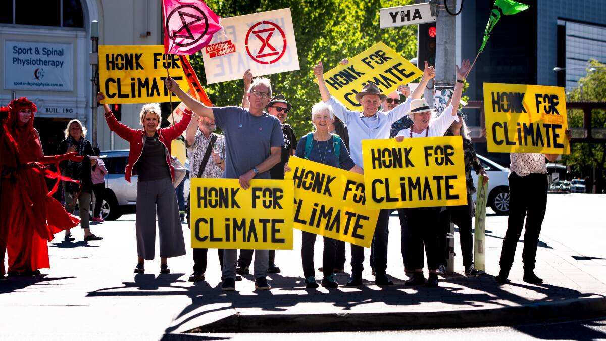 Older members of climate activist group Extinction Rebellion urge passing motorists on Northbourne Avenue to honk their horns for the climate. Picture: Elesa Kurtz