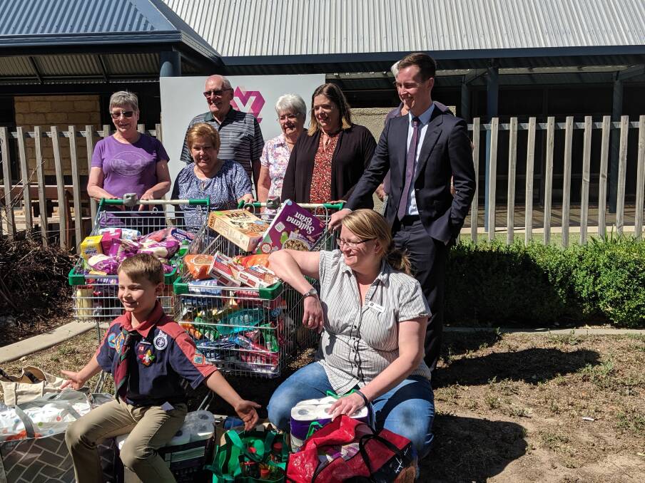 The staff and volunteers of YWCA Canberra's Lanyon Food Hub on Wednesday with seven-year-old Luke Bamford and City Services Minister Chris Steel.