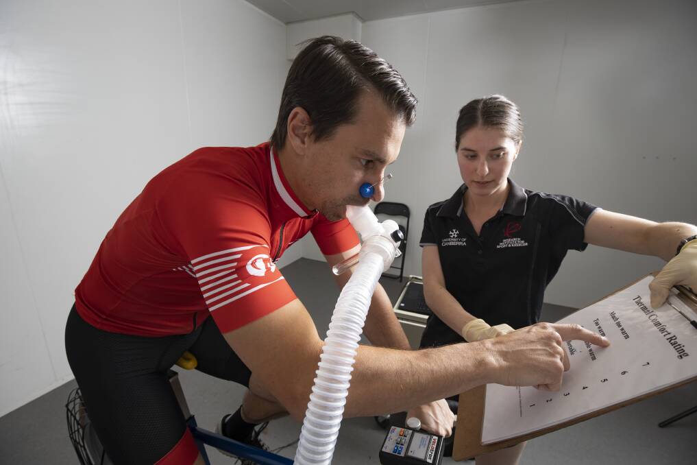 Cyclist Julien Periard rides in an environmental chamber, watched by University of Canberra PhD candidate Felicity Bright. Picture: Sitthixay Ditthavong