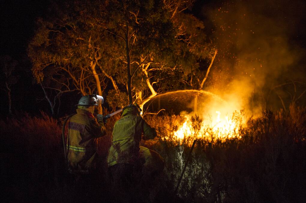 The RFS property protection unit work to protect Bombay houses from the remnants of the Tallaganda National Park bushfire. Picture: Dion Georgopoulos