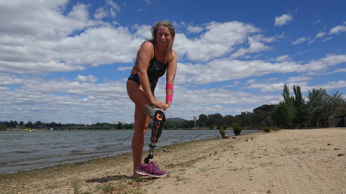Monique Murphy after swimming the length of Lake Burley Griffin. The Lifeline phone number is painted on her artificial leg. Picture: Steve Evans