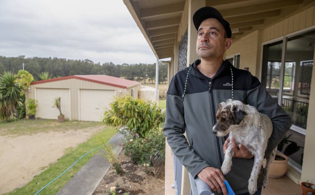 Jash Barber, pictured with his dog Charlie, stayed to protect his Bawley Point home. Picture: Sitthixay Ditthavong