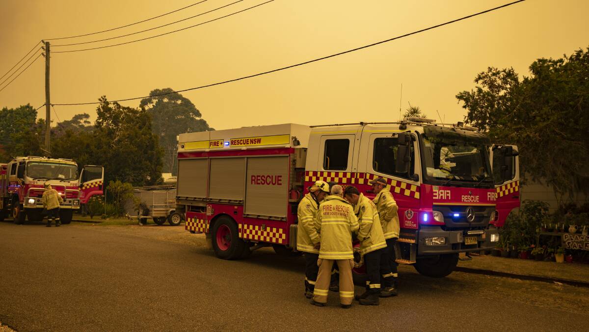 Fire crews revise their plans as a bushfire moves towards Bawley Point on Thursday afternoon. Authorities have warned people in affected areas to also be wary of scammers. Picture: Sitthixay Ditthavong