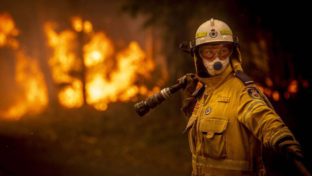 A NSW Rural Fire Service volunteer works to battle a bushfire on Murramarang Road in Bawley Point on Thursday afternoon. Picture: Sitthixay Ditthavong