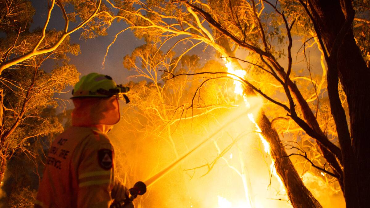 ACT Rural Fire Service crews assist to put out fires in Warri at the edge of the North Black Range bushfire on Thursday night. Picture: Dion Georgopoulos