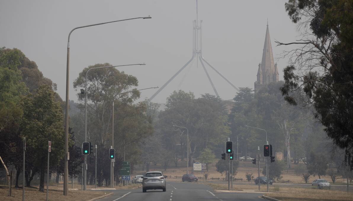 Parliament House and St Andrew's Presbyterian Church as seen through the smoke haze on Sunday. Picture: Sitthixay Ditthavong
