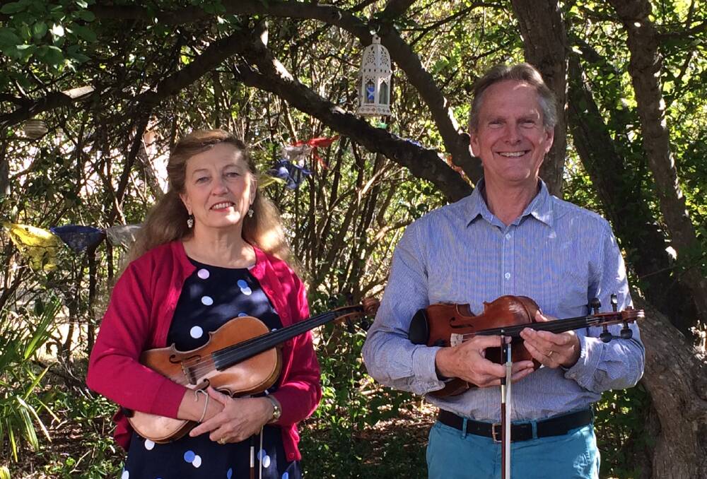 Jenny Gall and David Game with their musical instruments under their crab apple tree. Picture: Supplied