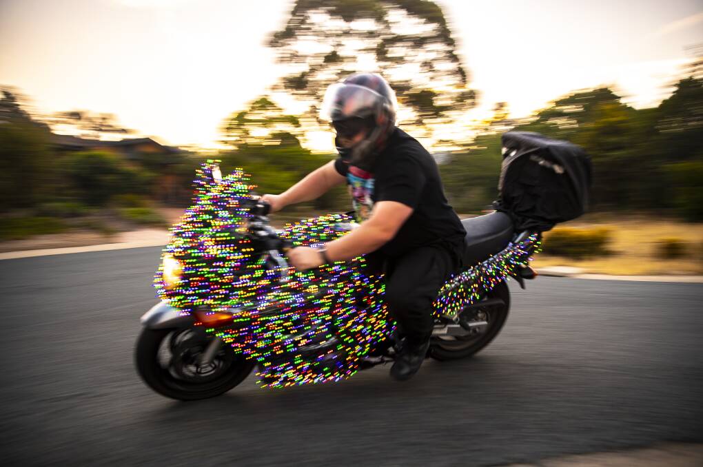 Stuart Murphy is turning heads as he rides around Canberra on his Suzuki GSXF750 motorbike decked out in hundreds of Christmas lights. Picture: Sitthixay Ditthavong