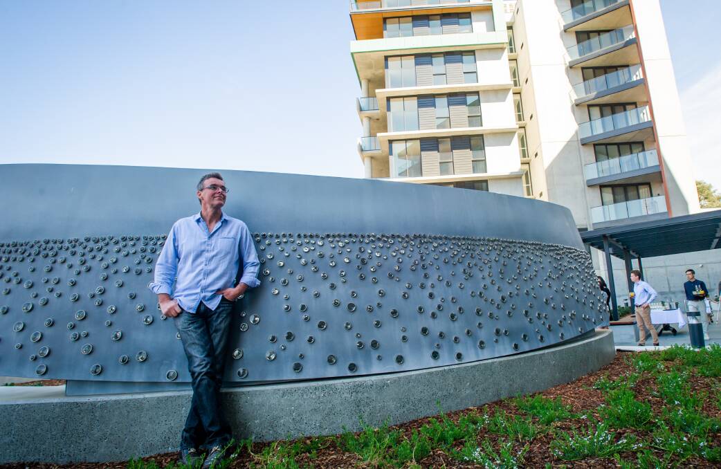 Matthew Curtis and his sculpture wall, which shimmers and changes colour at night. Picture: Karleen Minney