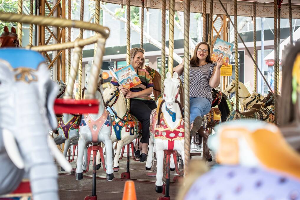 Author Samantha Tidy and illustrator Juliette Dudley on the Civic merry-go-round which features in their book Our Bush Capital. Picture: Karleen Minney