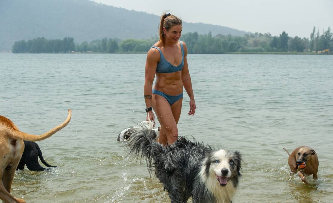 Jelena Dragila and her three dogs (Miles, Macey and Elliot) of Forde swim in Lake Burley Griffin on Saturday to cool down. Picture: Karleen Minney
