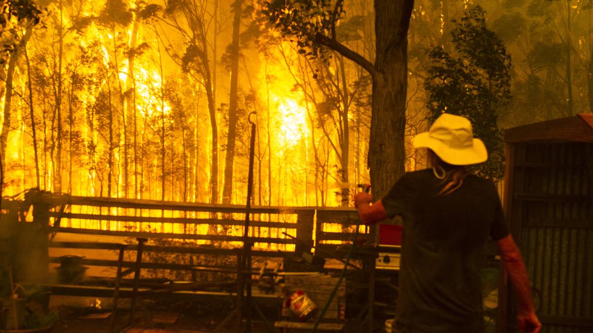 Michael Weekes protects his property on Jindelara Creek Rd from the Currowan fire. Picture: Dion Georgopoulos