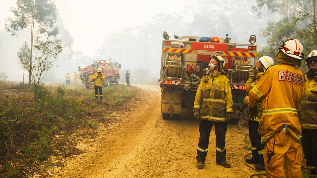 NSW Rural Fire Service firefighters come to protect a property on from the Currowan Fire earlier this month. Picture: Dion Georgopoulos