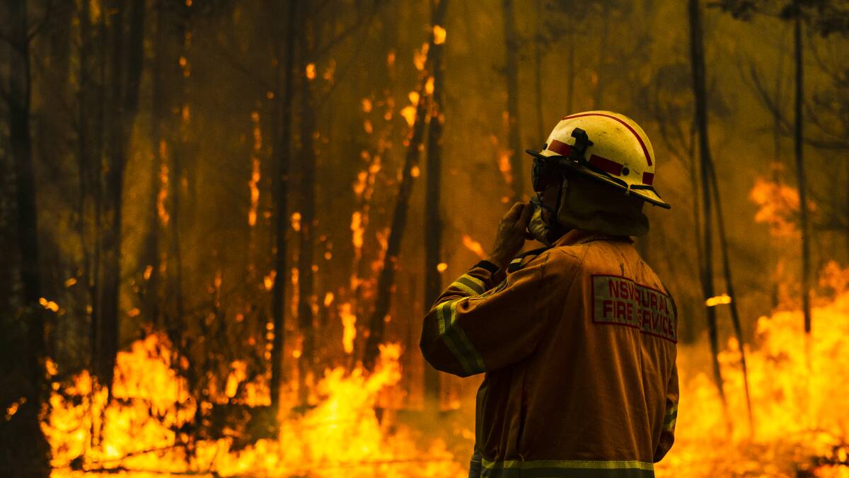 NSW Rural Fire Service firefighters protect a property on Tallow Wood Road. Picture: Dion Georgopoulos