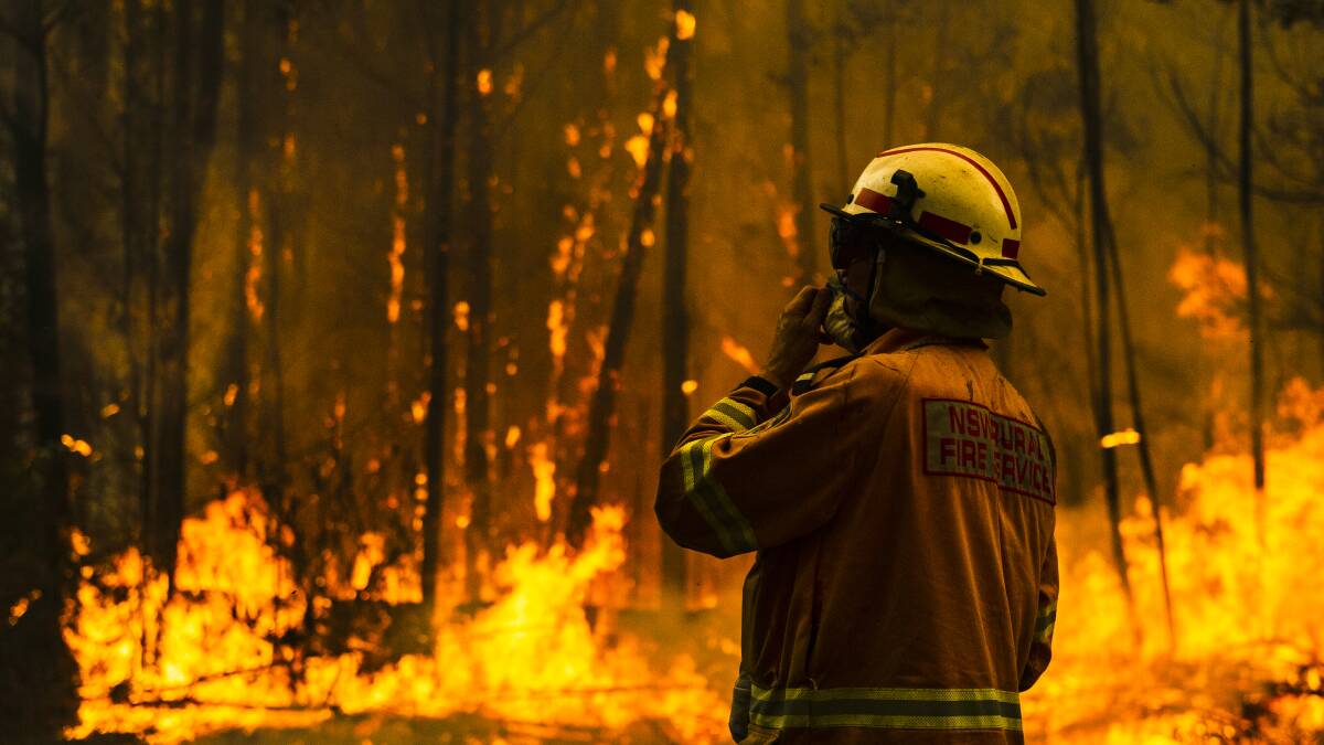 NSW Rural Fire Service firefighters protect a property from the Currowan Fire during Black Summer in 2019. Picture: Dion Georgopoulos