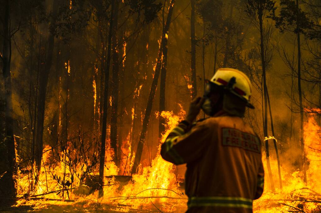 NSW Rural Fire Service firefighters come to protect a property on Tallow Wood Rd from the Currowan fire. Picture: Dion Georgopoulos