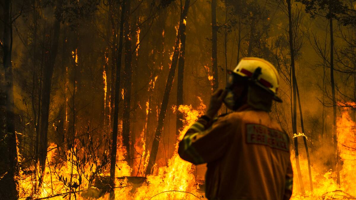 NSW Rural Fire Service firefighters come to protect a property on Tallow Wood Rd from the Currowan Fire on the weekend. Picture: Dion Georgopoulos