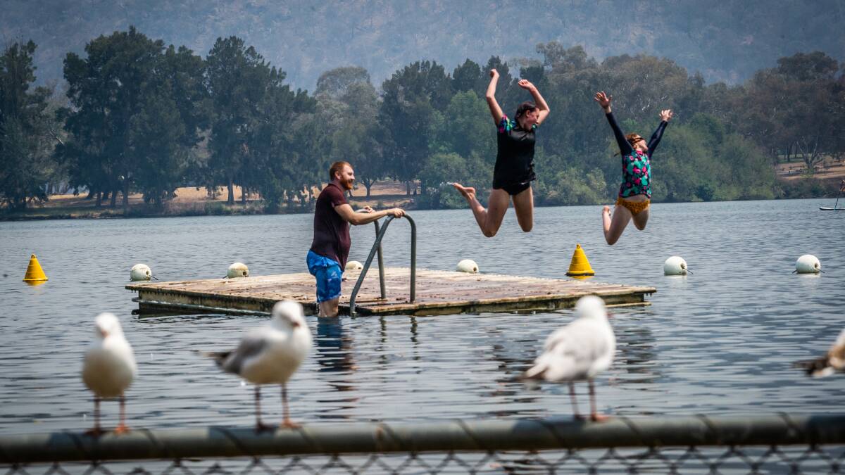 James McPhail of Ngunnawal and daughters Dallandra, 14, and Brodie,12 play on a floating jetty on Lake Burley Griffin. Picture: Karleen Minney