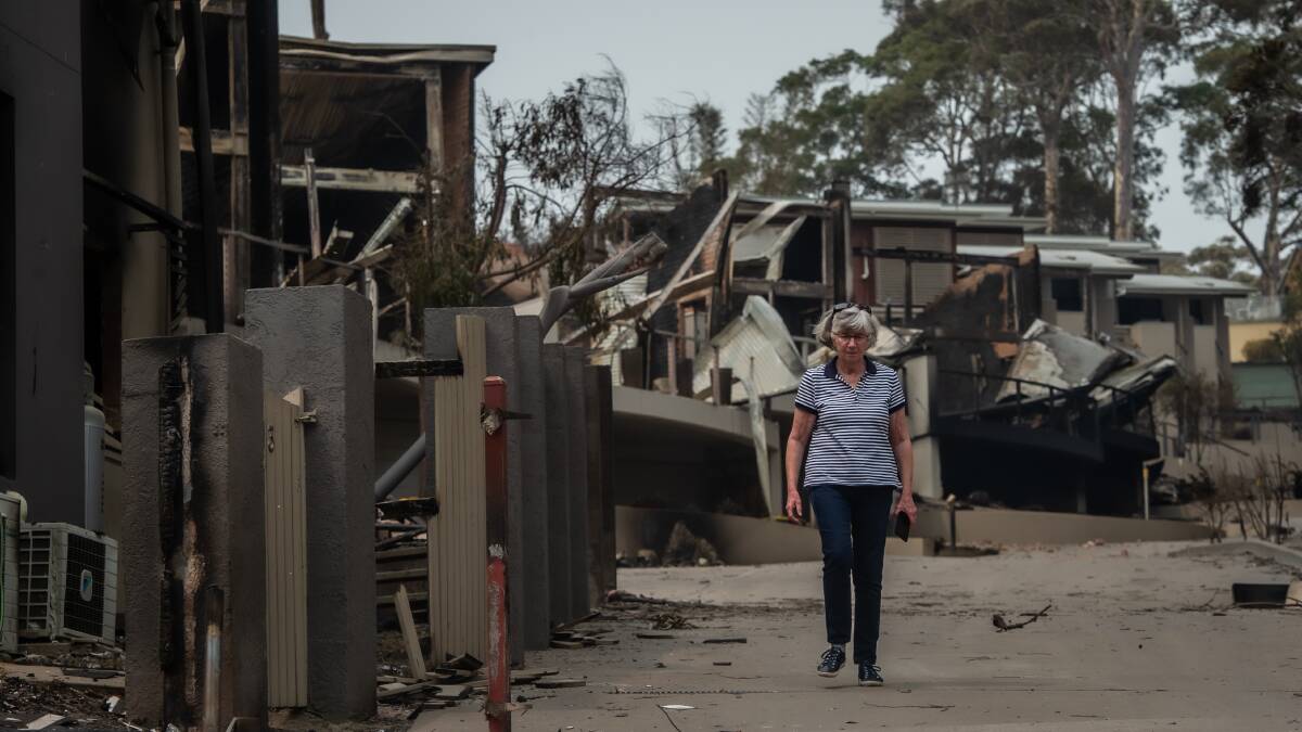 Susan Magnay examines the damage to her Malua Bay home on New Year's Day 2020. Picture: Karleen Minney