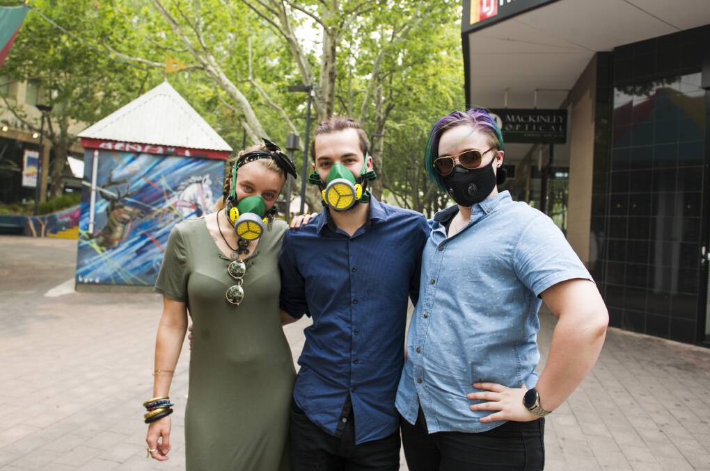 Alice Bilton-Simek, Tobias Price, and Sebastian Winter wearing masks to protect themselves from the thick smoke in Canberra. Picture: Dion Georgopoulos
