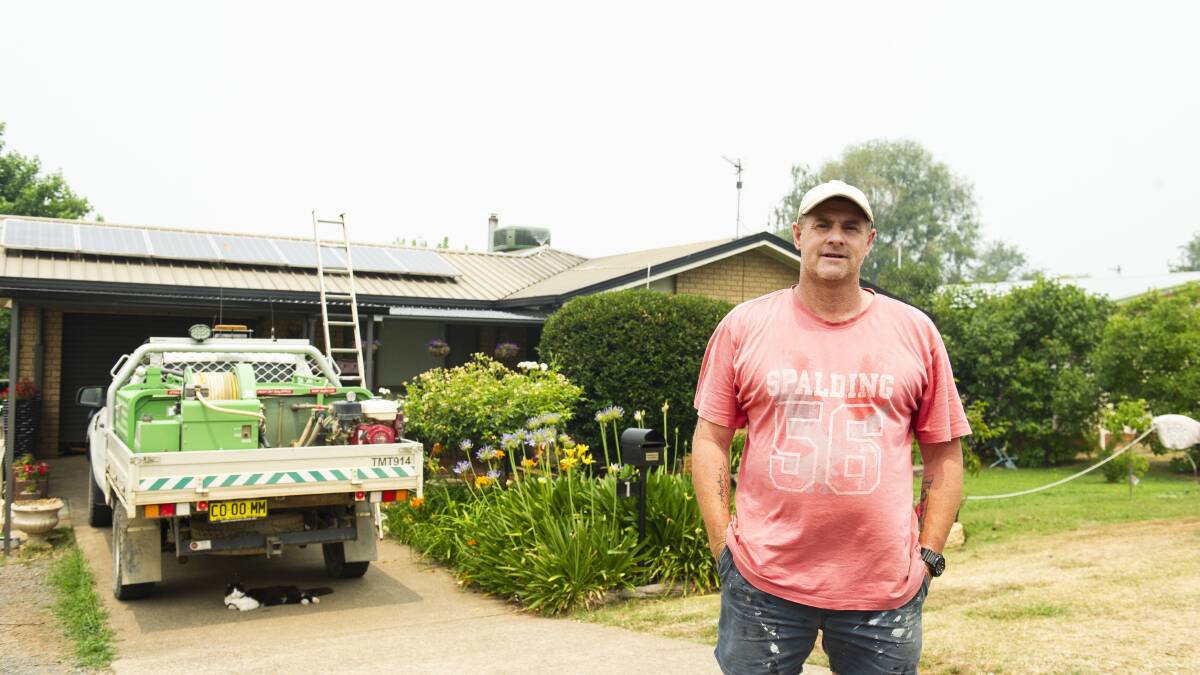 Batlow resident Graham Salmon works to prepare his home as the Dunns Road fire approaches. Picture: Dion Georgopoulos