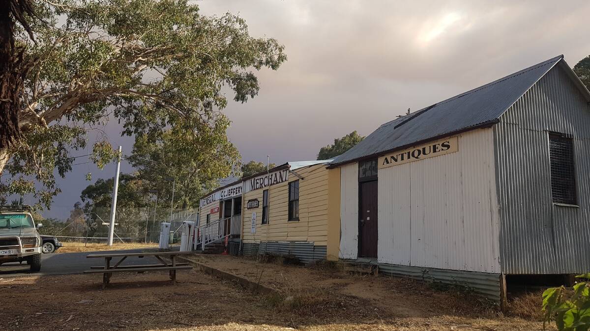 Smoke rolls across the sky above the general store at Tharwa at 6pm on Saturday. Picture: Harry Logus