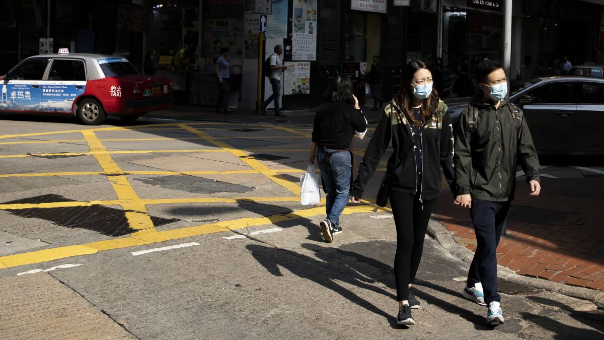 A couple wear face masks as they walk through Hong Kong's Sheung Wan district on Tuesday afternoon. Picture: Sitthixay Ditthavong