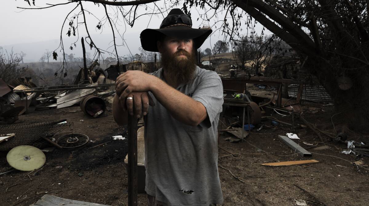 Jade Corby surveys his parents' property at Wandella, which was destroyed by bushfire. It's important people have time to process pain before picking up the pieces, argues John Falzon. Picture: Dion Georgopoulos