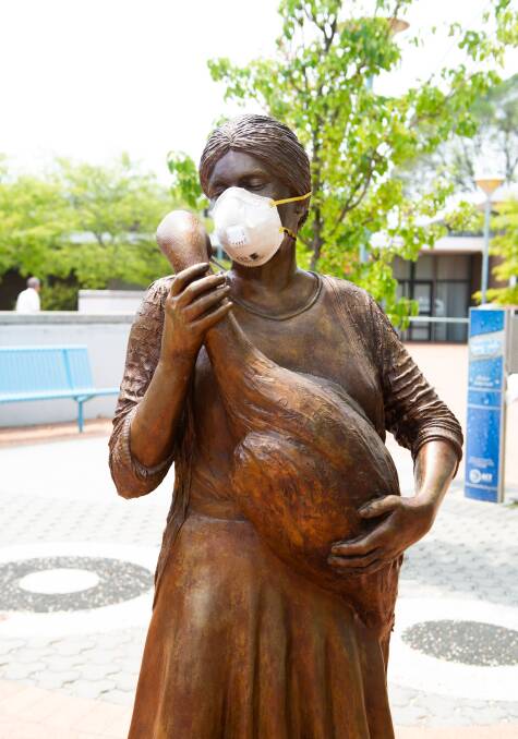 A face mask on a statue in Hughes. Picture: Elesa Kurtz