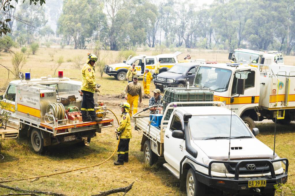 Locals and ACT Rural Fire Service Gungahlin brigade clear a spot fire in Yaouk. Picture: Dion Georgopoulos
