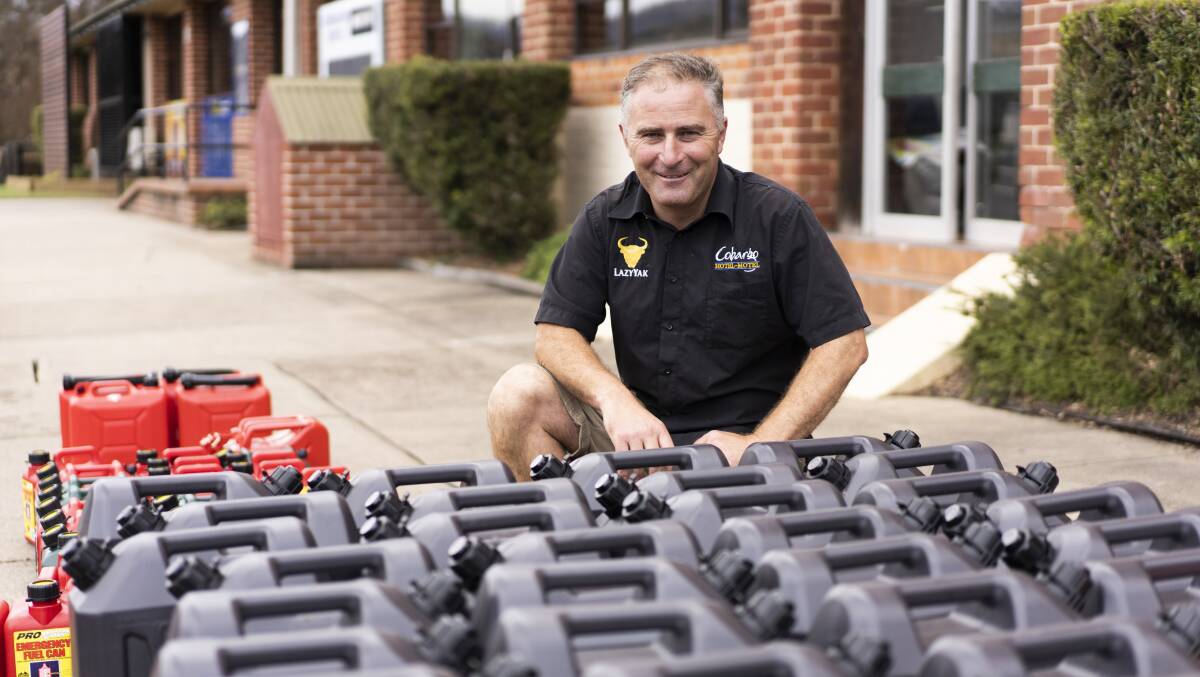Owner of the Cobargo Hotel David Allen with the jerry cans, filled by fuel donated from Canberra and lined up for locals and farmers in need. Picture: Dion Georgopoulos