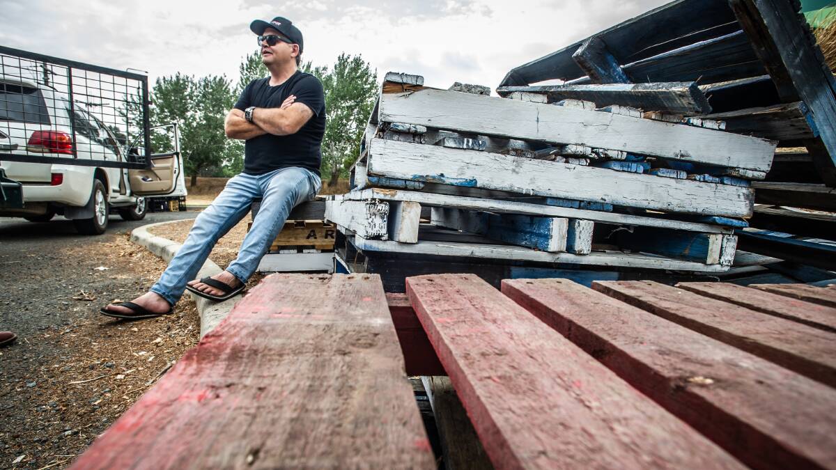 Andrew Dale takes a break on a pile of empty pallets that once held donated items. Picture: Karleen Minney