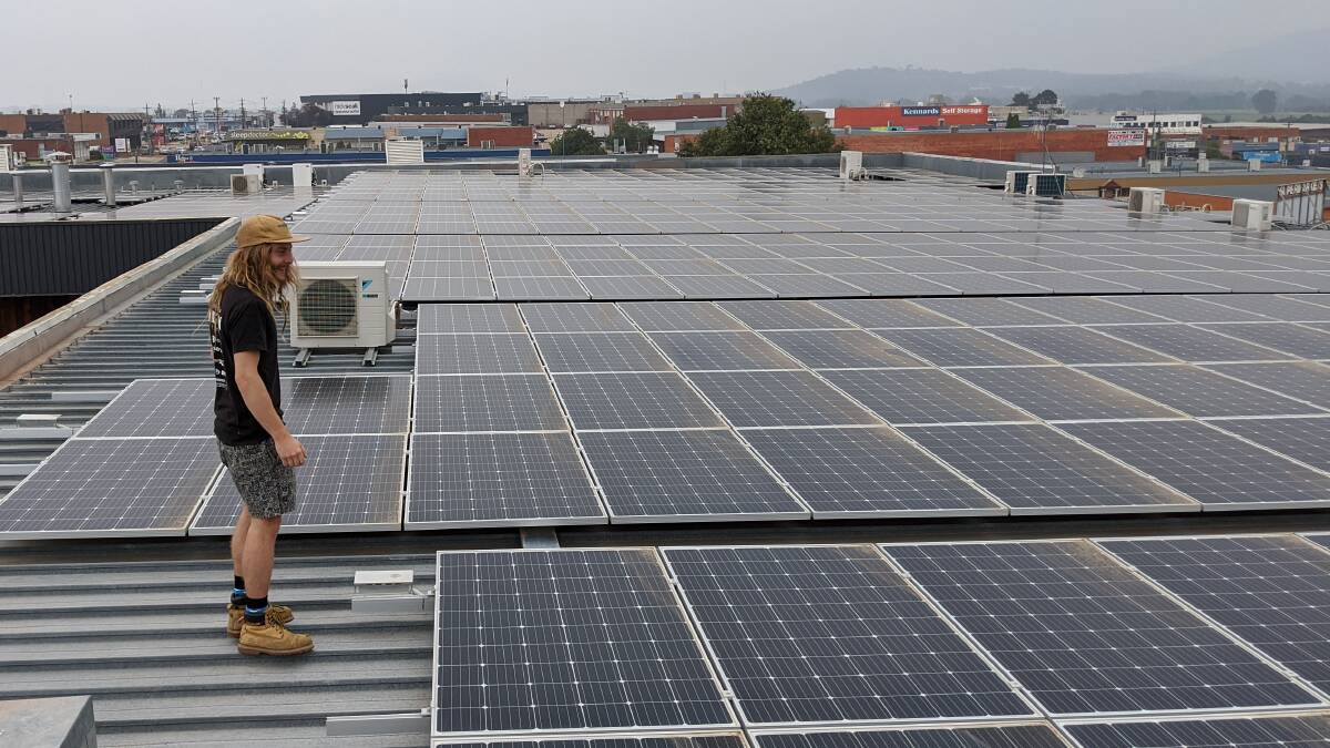 Ona Coffee warehouse assistant Joey Niddrie on the roof of the Fyshwick factory with the 500 solar panels. Picture: Supplied