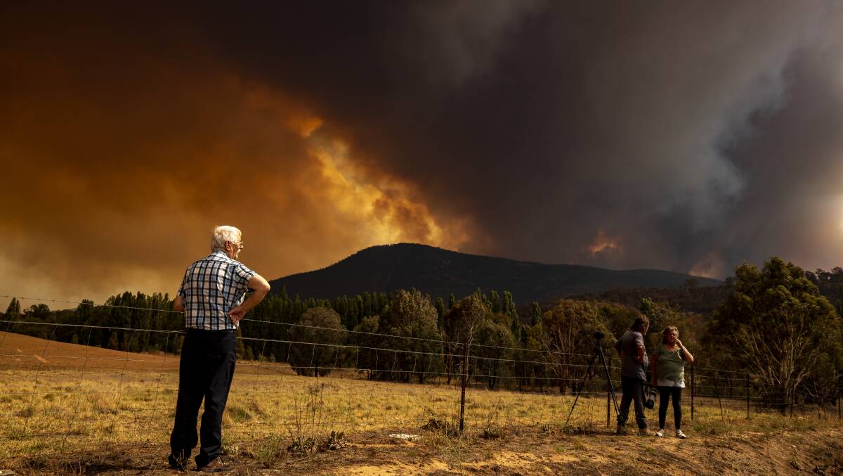 People gather outside Tharwa in January as a bushfire burns in Namadgi National Park. Picture: Sitthixay Ditthavong
