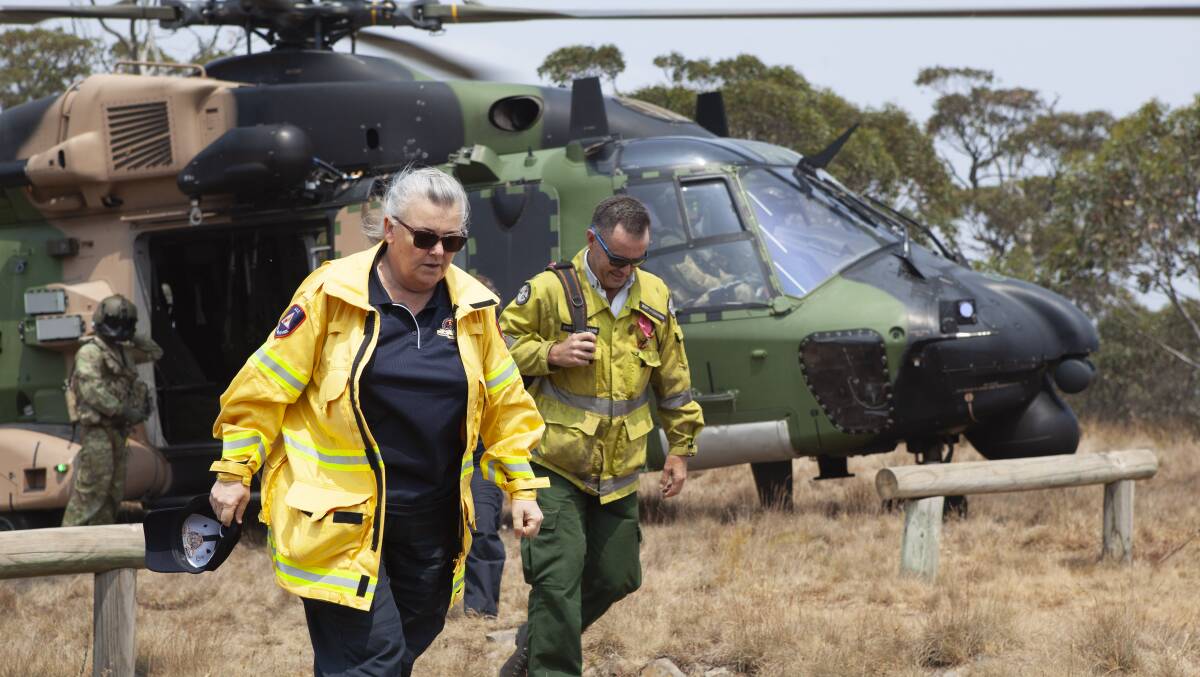 ACT Emergency Services Agency Commissioner, Ms. Georgeina Whelan and Brett McNamara, the Area Manager for the Namadgi National Park disembark from an MRH-90 Taipan helicopter at Mt Ginini. Picture: Department of Defence