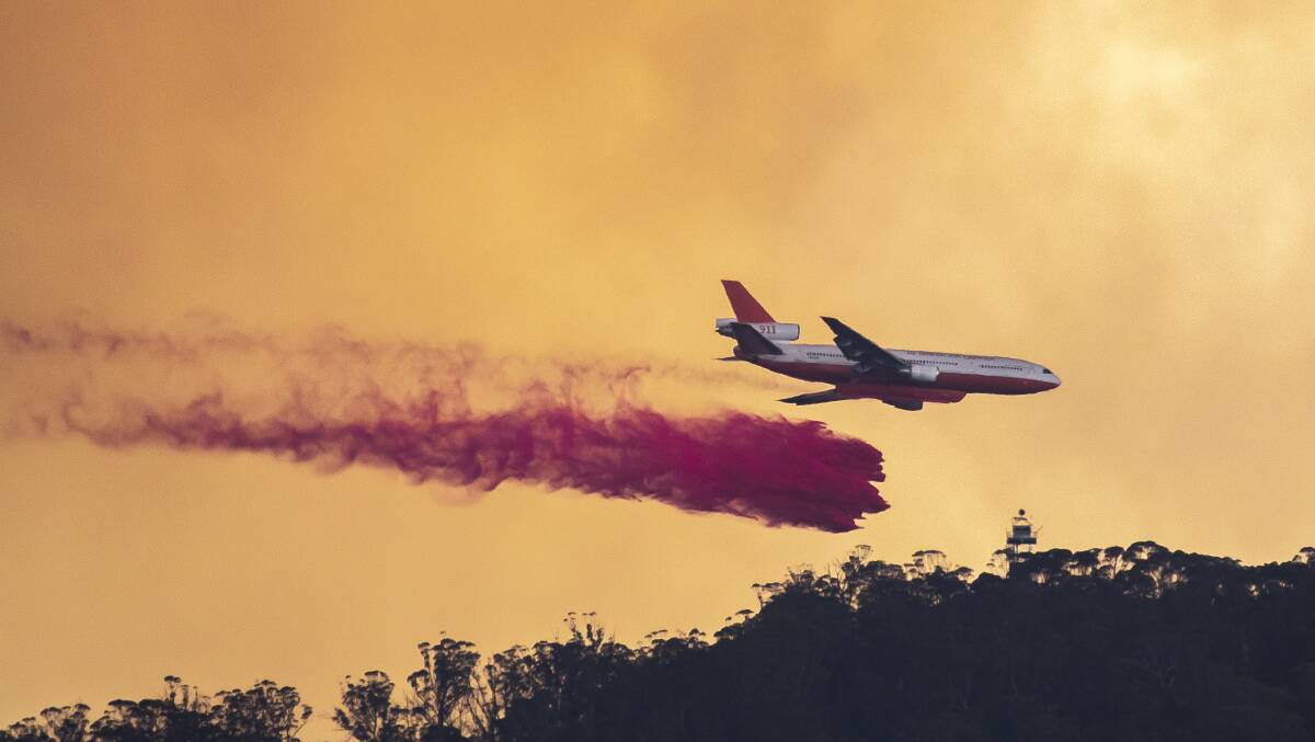An aircraft drops fire retardant on Mt Tennant earlier this year. Picture: Sitthixay Ditthavong
