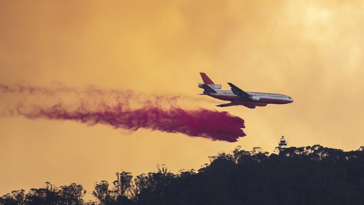 An aircraft drops fire retardant while battling the Orroral Valley Fire in January. Picture: Sitthixay Ditthavong