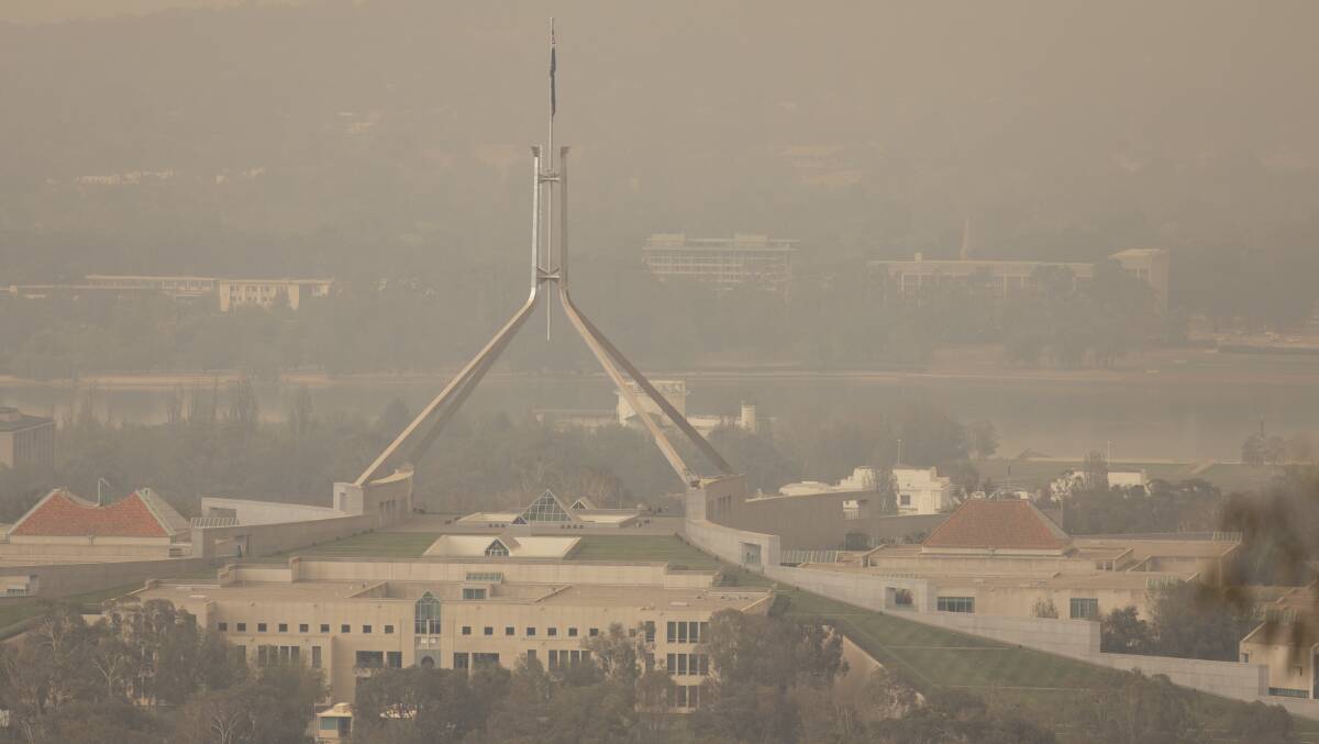 Bushfire smoke shrouds Parliament House. A former fire chief believes current officials are 'self-censoring' on climate change. Picture: Sitthixay Ditthavong