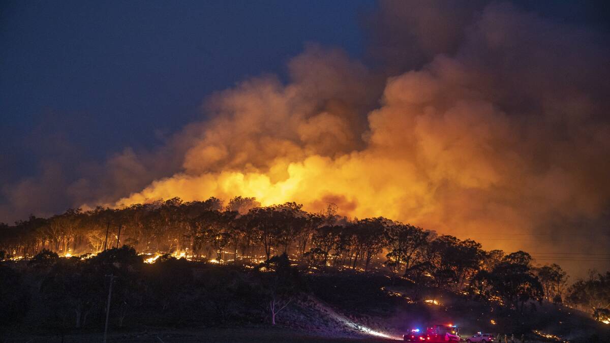 A spot fire from the Clear Ridge bushfire flares up on Saturday evening in Michelago. Picture: Sitthixay Ditthavong