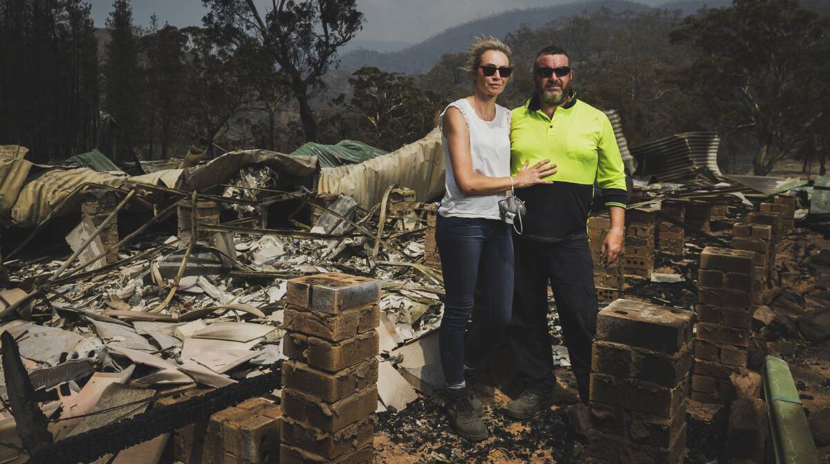 Annika Safe and Stephen Littlehales with the remains of their Bumbalong Valley home, which was destroyed by fire. Picture: Dion Georgopoulos