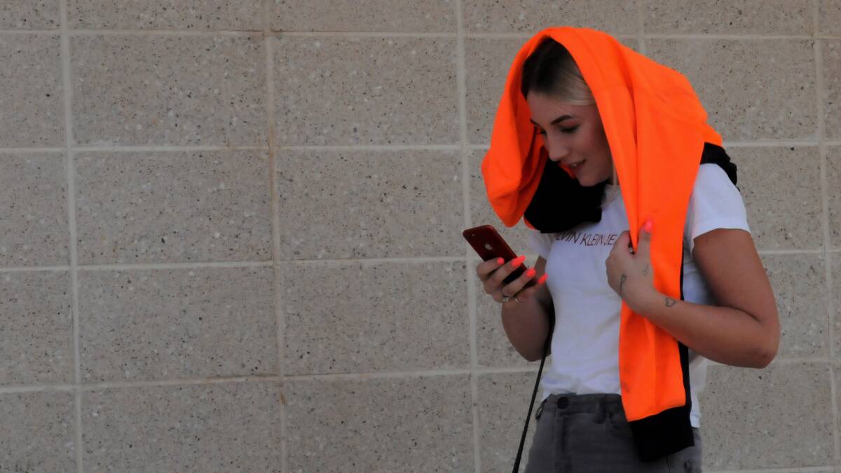 Jasmin Parker, 19, leaves court on Tuesday with a high-vis vest that she had earlier used to shield her face from the camera. Picture: Blake Foden