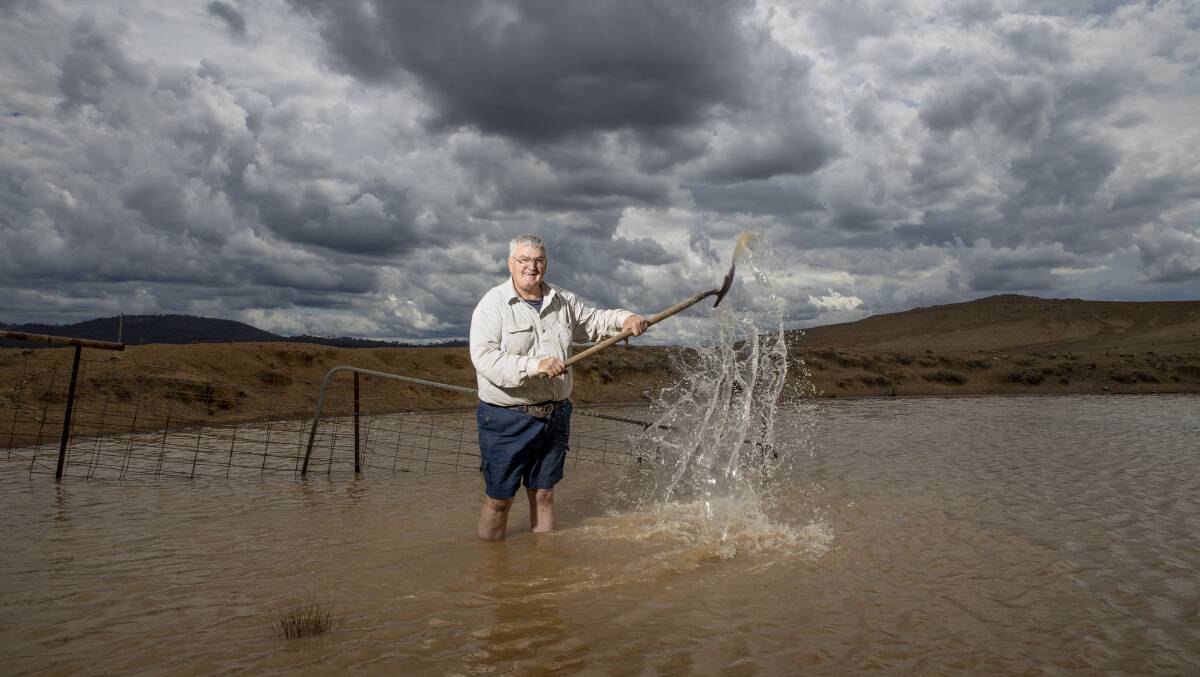 Canberra district grazier Tom Allen in one of his dams that was cracked and bone dry just two days ago. Picture: Sitthixay Ditthavong