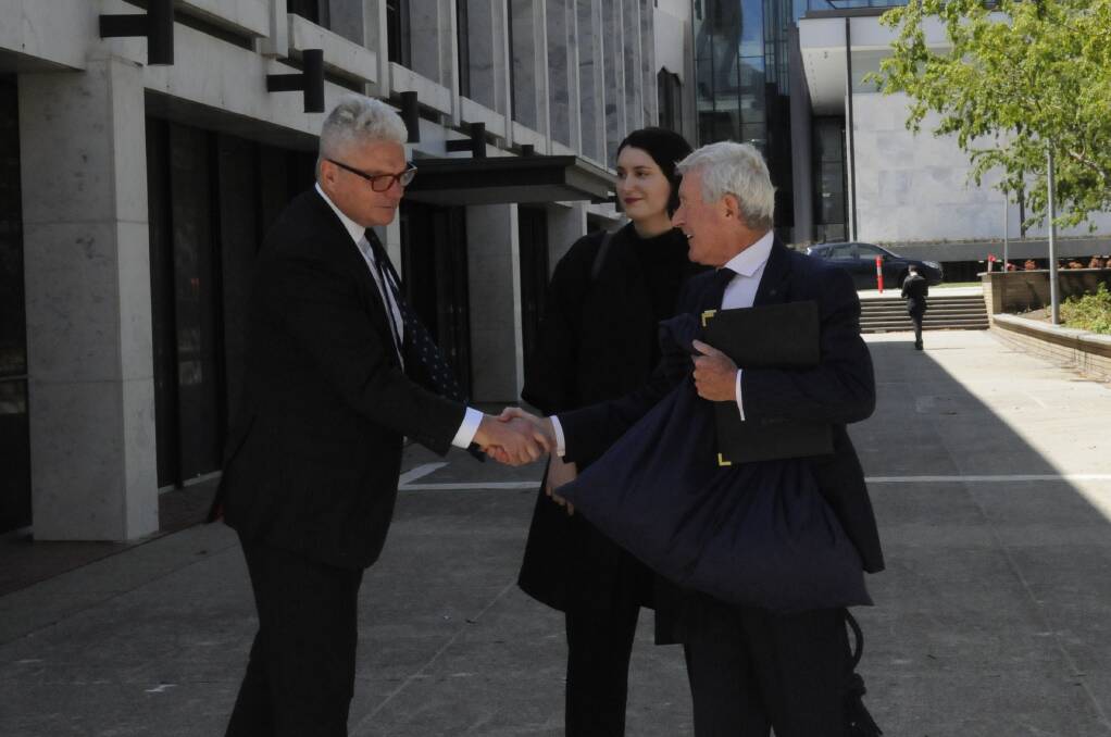 David McBride shakes hands with barrister Bernard Collaery after leaving the ACT Supreme Court on Friday. Picture: Blake Foden