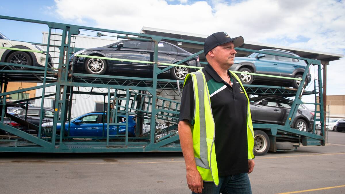 Carways' Scott Brown with hail-damaged cars loaded up on one of the company's distinctive green trucks. Picture: Elesa Kurtz 