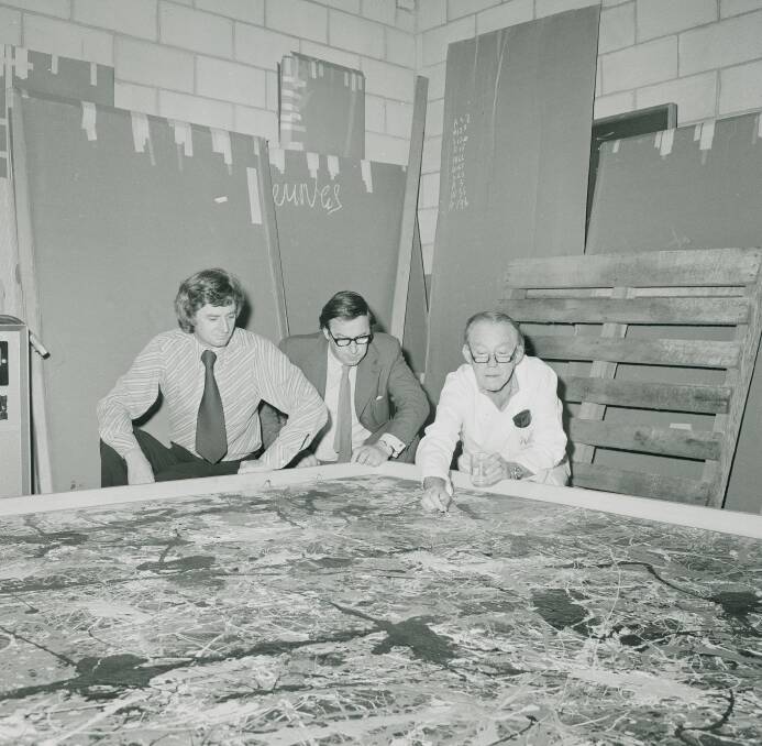 National Gallery director James Mollison, left, inspects Blue Poles as it is being prepared for hanging in New South Wales, 1974. Picture: National Archives of Australia
