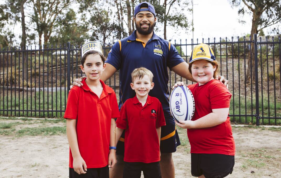 Folau Fainga'a played touch football with students, from left, Connor Holly, 10, William Darmody, 7, and Hayley Lewis, 9. Picture: Jamila Toderas