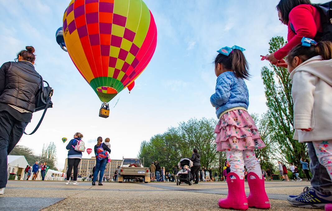 Canberrans watch the start of the Balloon Spectacular near Old Parliament House. Picture: Elesa Kurtz