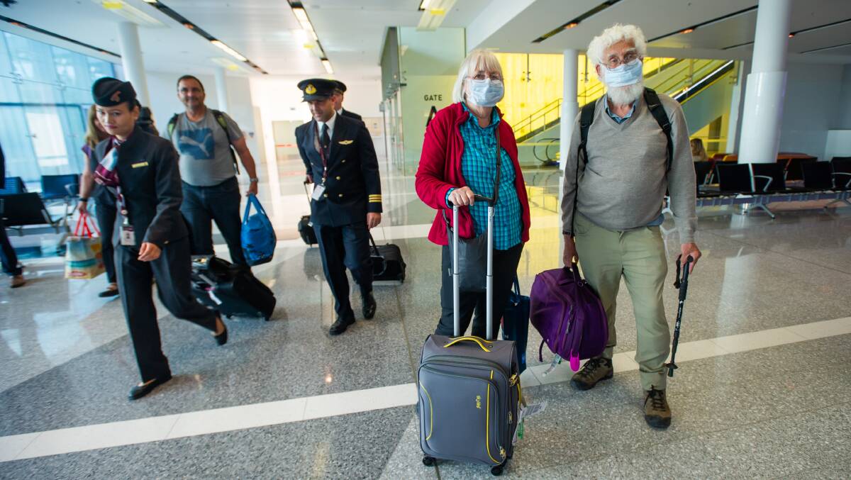 Helen and Kevin Curtis of Gundaroo arrive at Canberra Airport from Doha via Sydney on Monday morning. The couple have had to cut their overseas holiday short by two weeks and will now need to self-isolate for 14 days. Picture: Karleen Minney