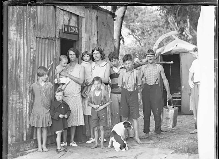 A family standing outside a tin shack called Wiloma in NSW during the Great Depression in 1932. Picture: National Library of Australia