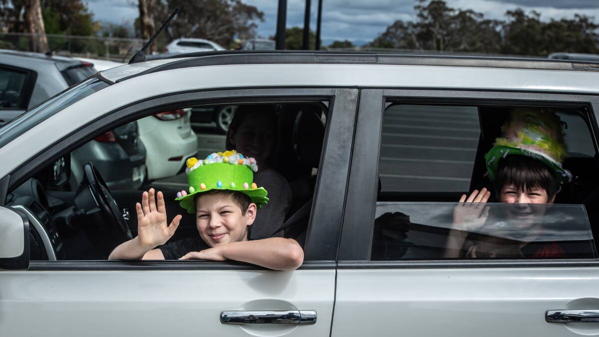 Brothers Matthew and Joshua Philpott take part in the Good Shepherd Catholic Primary School Easter hat parade from a safe distance, via their family car. Picture: Karleen Minney